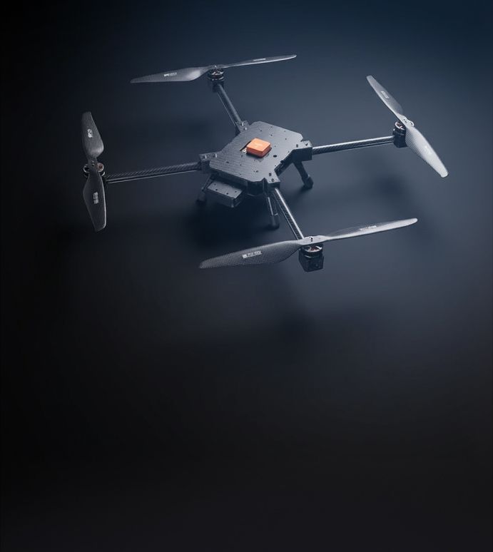 A sleek, dark quadcopter drone with four propellers and a front-mounted camera on a dark background.