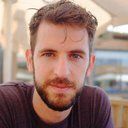 A man with short brown hair and a beard looks directly at the camera.