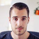 Headshot of a man with dark hair and a light beard looking forward.